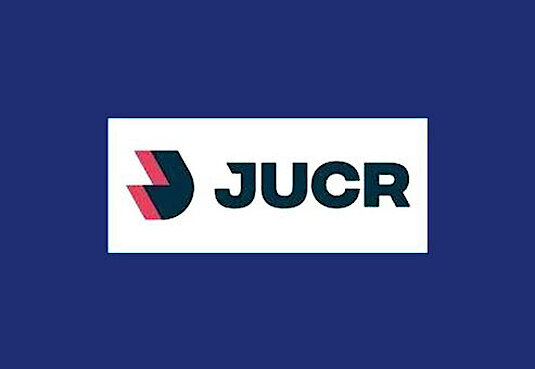 Logo in rot und schwarz mit dem Schriftzug JUCR auf einem dunkelblauen Hintergrund
