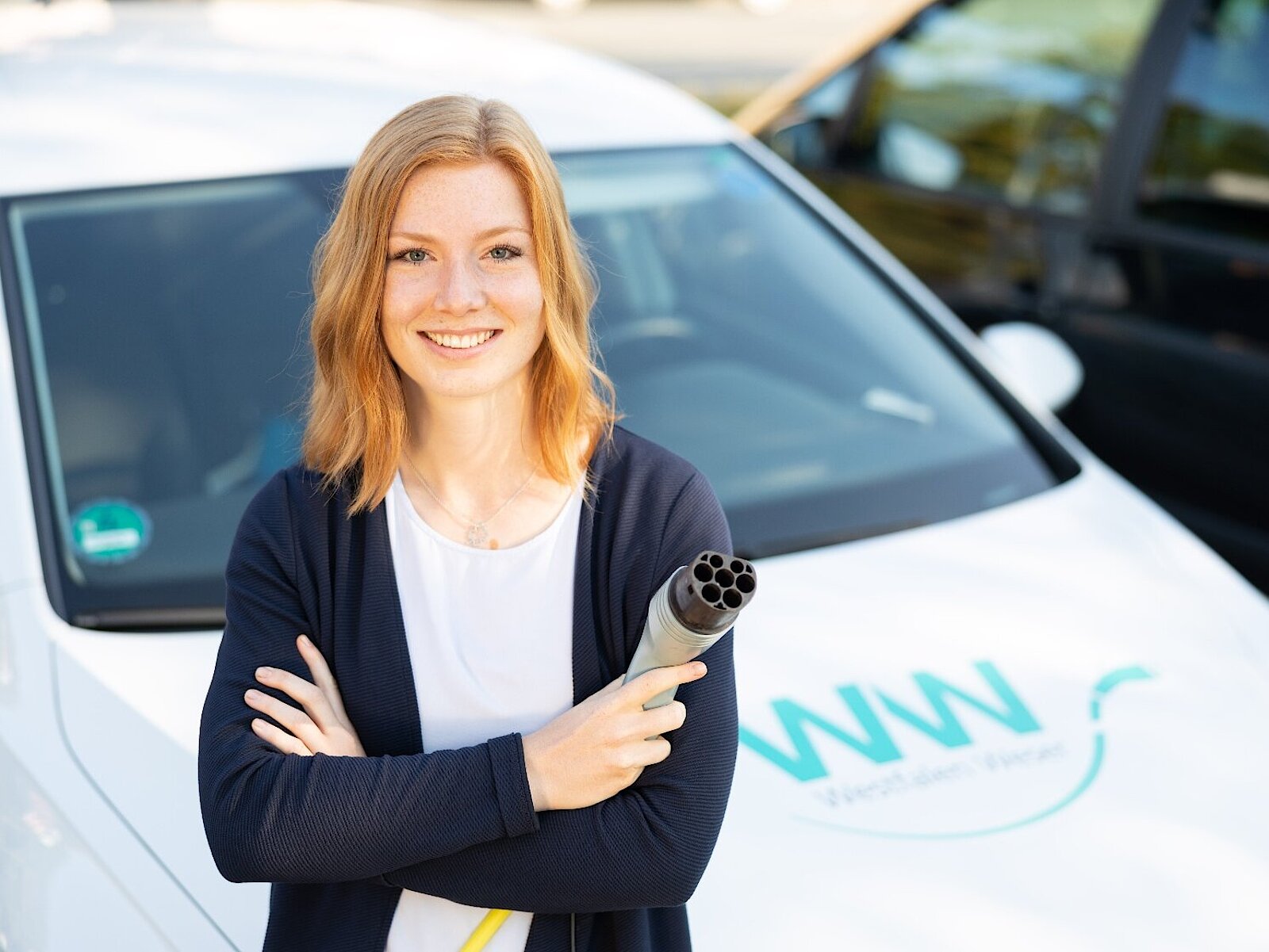 Frau beim Aufladen mit Stecker für Elektroauto Westfalen Weser